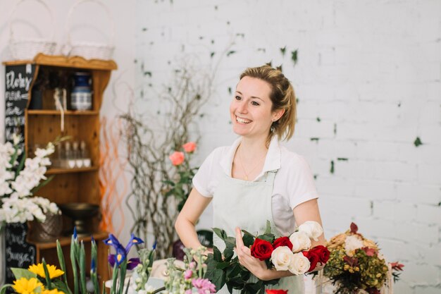 Cheerful florist holding rose bouquet