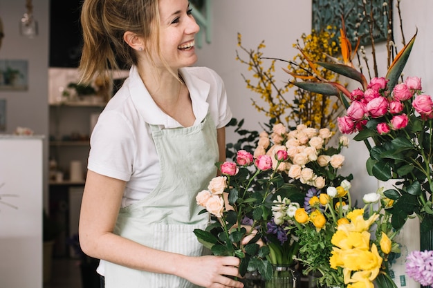 Cheerful florist near bouquets