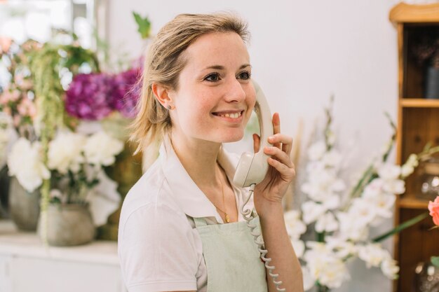 Cheerful florist speaking on phone