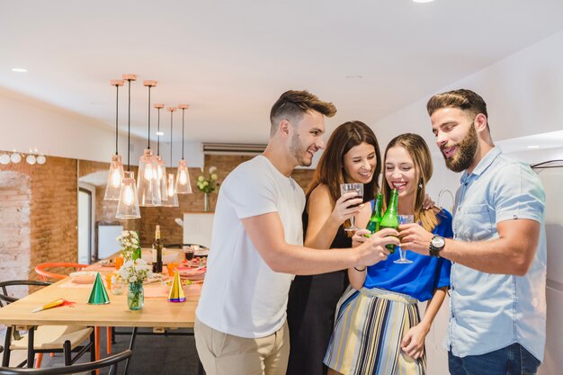 Cheerful friends clinking with drinks