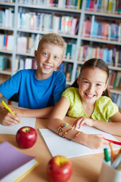 Cheerful friends doing homework