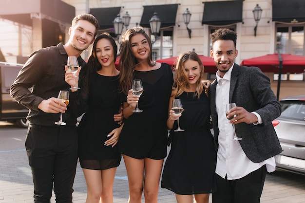 Free photo cheerful friends drinking champagne at party outdoors