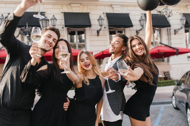 cheerful friends drinking champagne at party outdoors