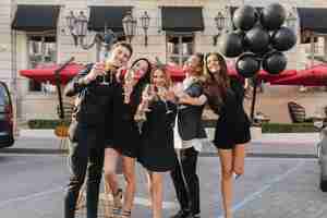 Free photo cheerful friends drinking champagne at party outdoors