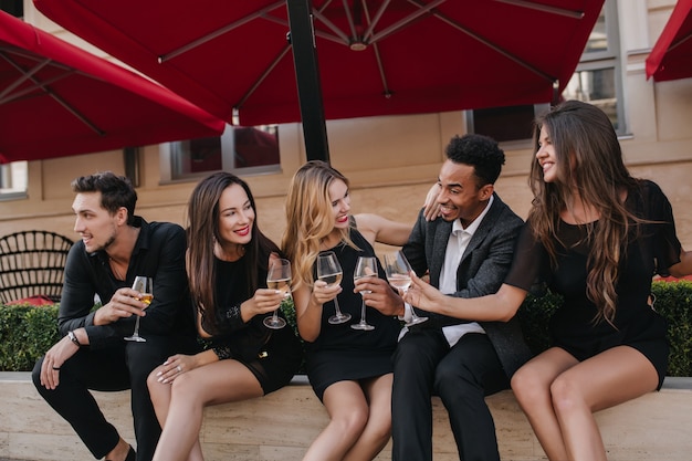 Free photo cheerful friends drinking champagne at party outdoors