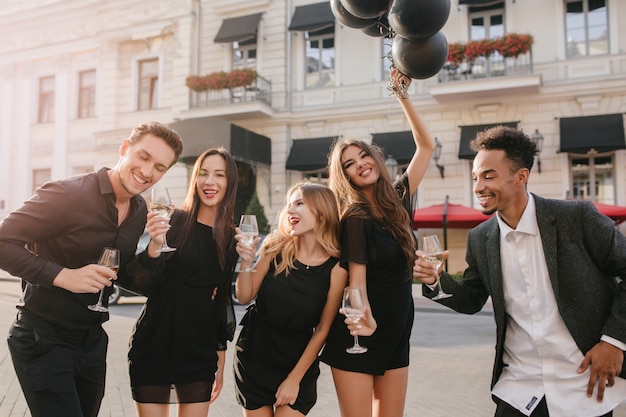 Free photo cheerful friends drinking champagne at party outdoors