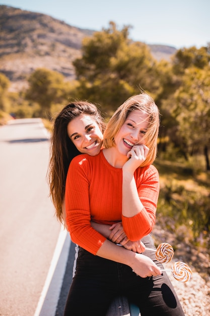 Cheerful friends embracing on guard rail