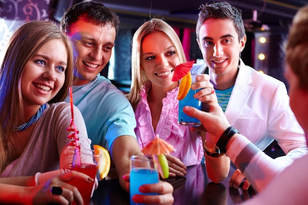 Cheerful friends holding cocktails