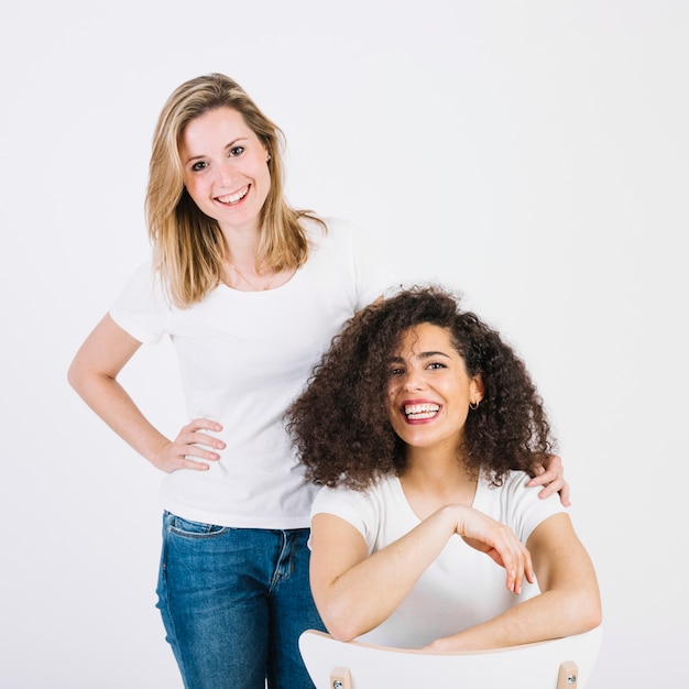 Free photo cheerful friends near chair