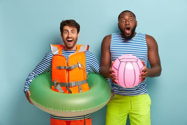 cheerful friends posing with beach items