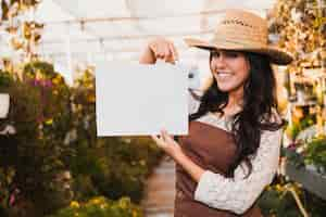 Free photo cheerful gardener pointing at paper sheet