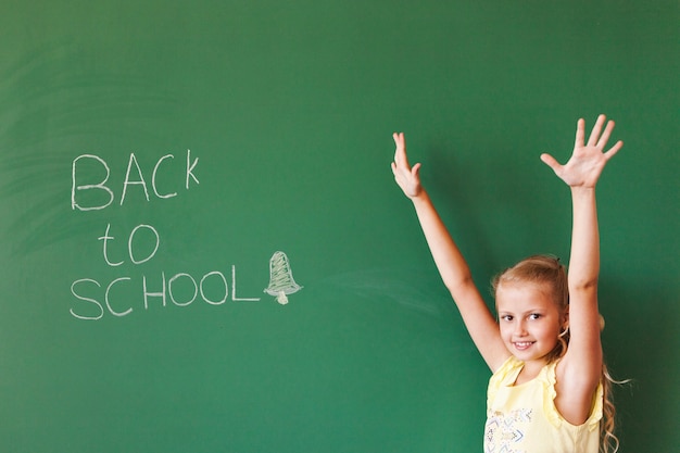 Cheerful girl at blackboard