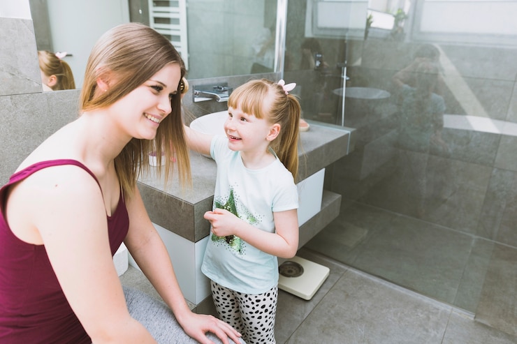 Free Photo cheerful girl brushing hair of mother