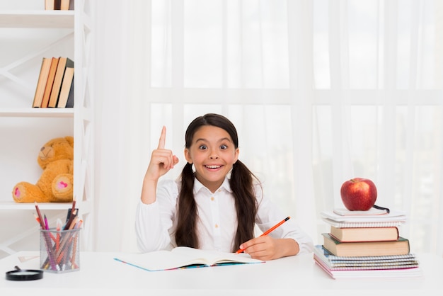 Cheerful girl doing homework with joy