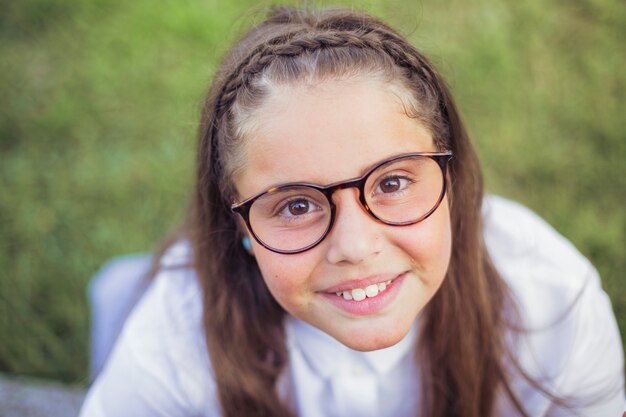 Cheerful girl in eyeglasses with brown eyes looking and smiling