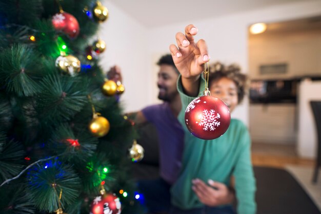 Cheerful girl holding Christmas decoration and enjoying holidays