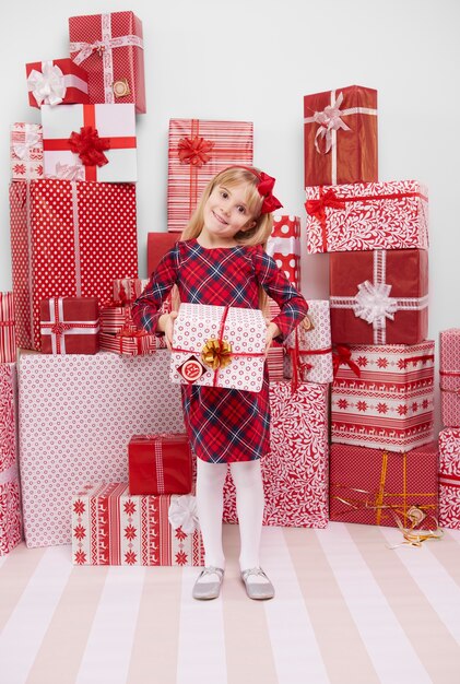 Cheerful girl holding red present