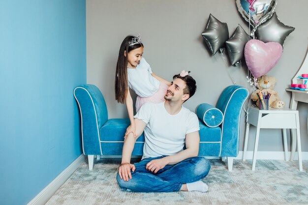 Cheerful girl is showing her father his hairstyle