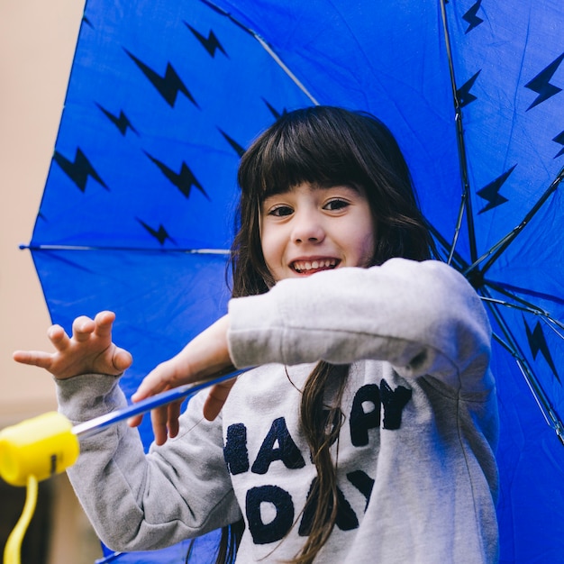 Cheerful girl playing with umbrella