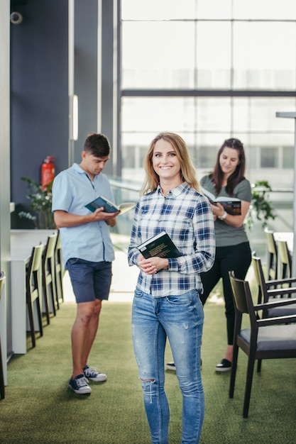 Cheerful girl with friends in library