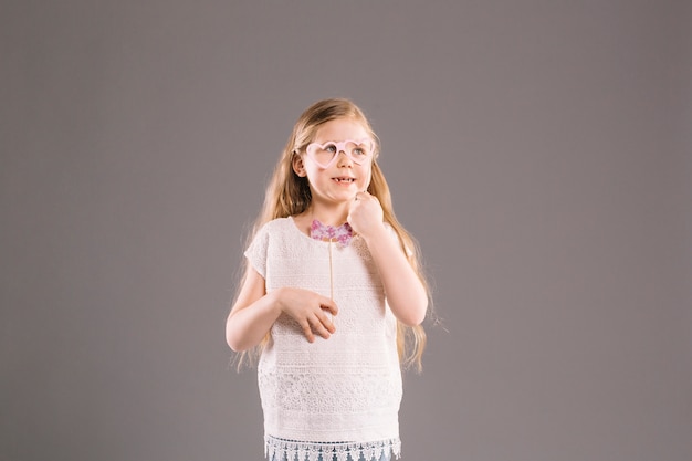 Cheerful girl with glasses and bow tie