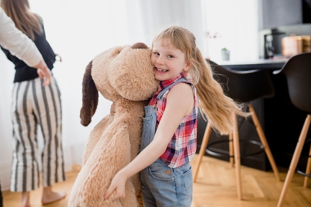 Cheerful girl with plush dog