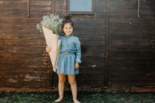 Cheerful girl with wild flowers bouquet 