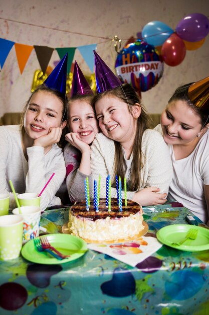 Cheerful girls near nice cake