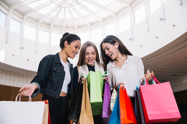 Free photo cheerful girls in shopping mall together