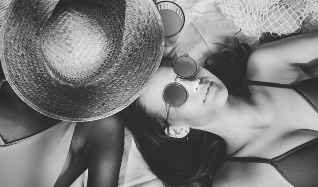 Cheerful girls in swimsuit suntanning together