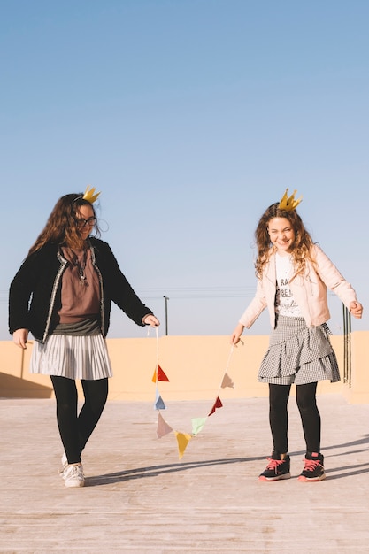 Cheerful girls with garland on roof