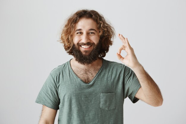 Cheerful good-looking middle-eastern guy show okay gesture, guarantee quality