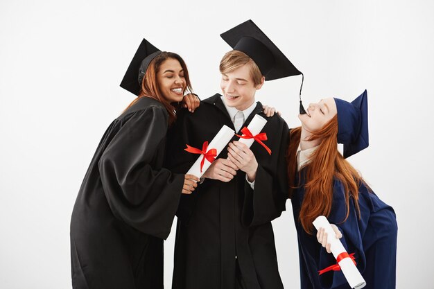 Cheerful graduate classmates celebrating smiling rejoicing.