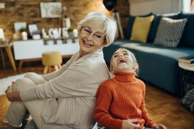 Cheerful grandmother and granddaughter having fun at home