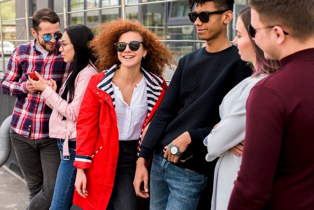 Cheerful group of friends standing near building