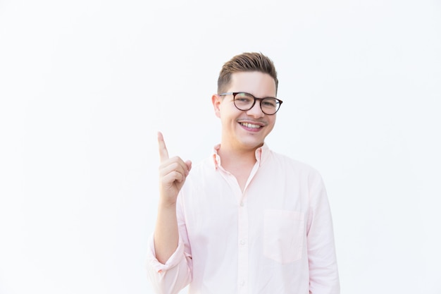 Cheerful guy in eyewear pointing finger up