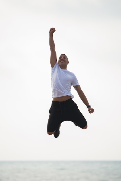 Free photo cheerful guy feeling power and energy in mid-air