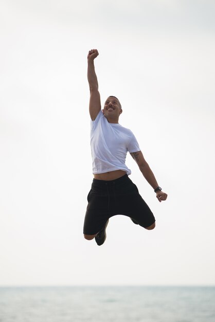 Cheerful guy feeling power and energy in mid-air