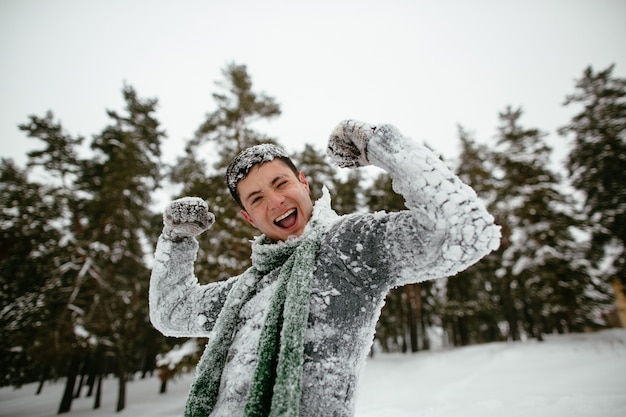 Веселый парень покрыт снегом. Веселое зимнее время.