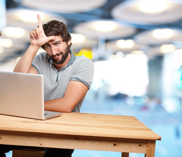 Ragazzo allegro, lavorando con il computer portatile