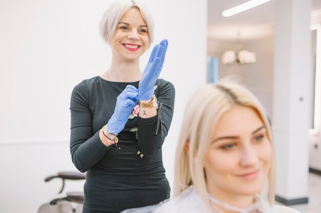 Cheerful hairdresser preparing for coloring procedure