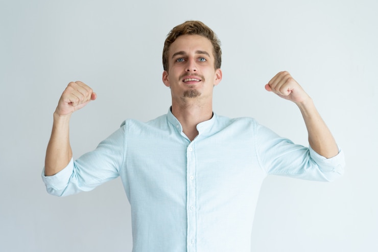 Free Photo cheerful handsome young man pumping fists. guy celebrating achievement.