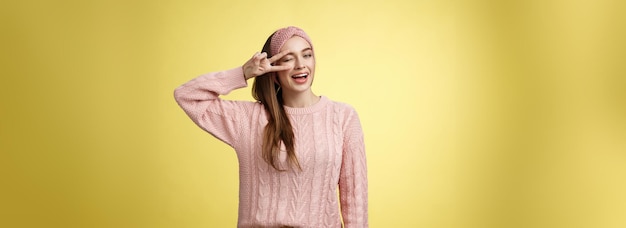 기쁜 행복한 화려한 젊은 유럽 여성은 분홍색 뜨개질 스웨터를 입고 머리을 착용하고 눈 여 유혹합니다.