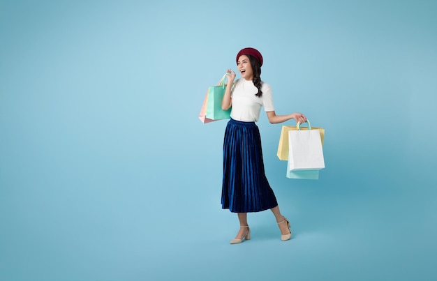 Free photo cheerful happy thai asian woman enjoying shopping she is carrying shopping bags and walking