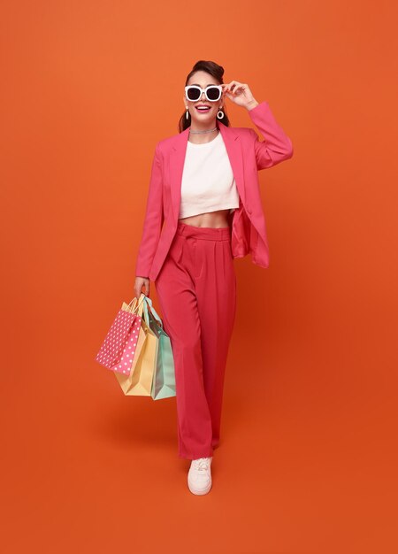 Cheerful happy woman enjoying shopping summer sale she is carrying shopping bags and walking