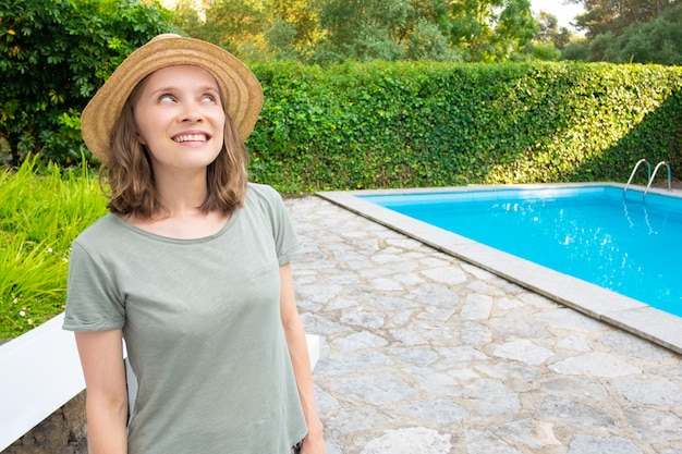 Cheerful happy woman in summer outfit standing in garden