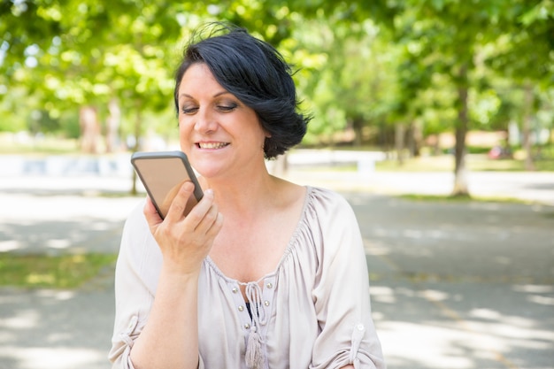 Cheerful happy woman talking on speaker