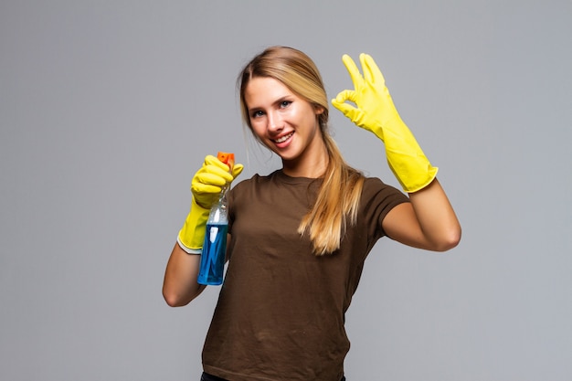 Cheerful housekeeper female showing ok sign as great cleaning services concept on white