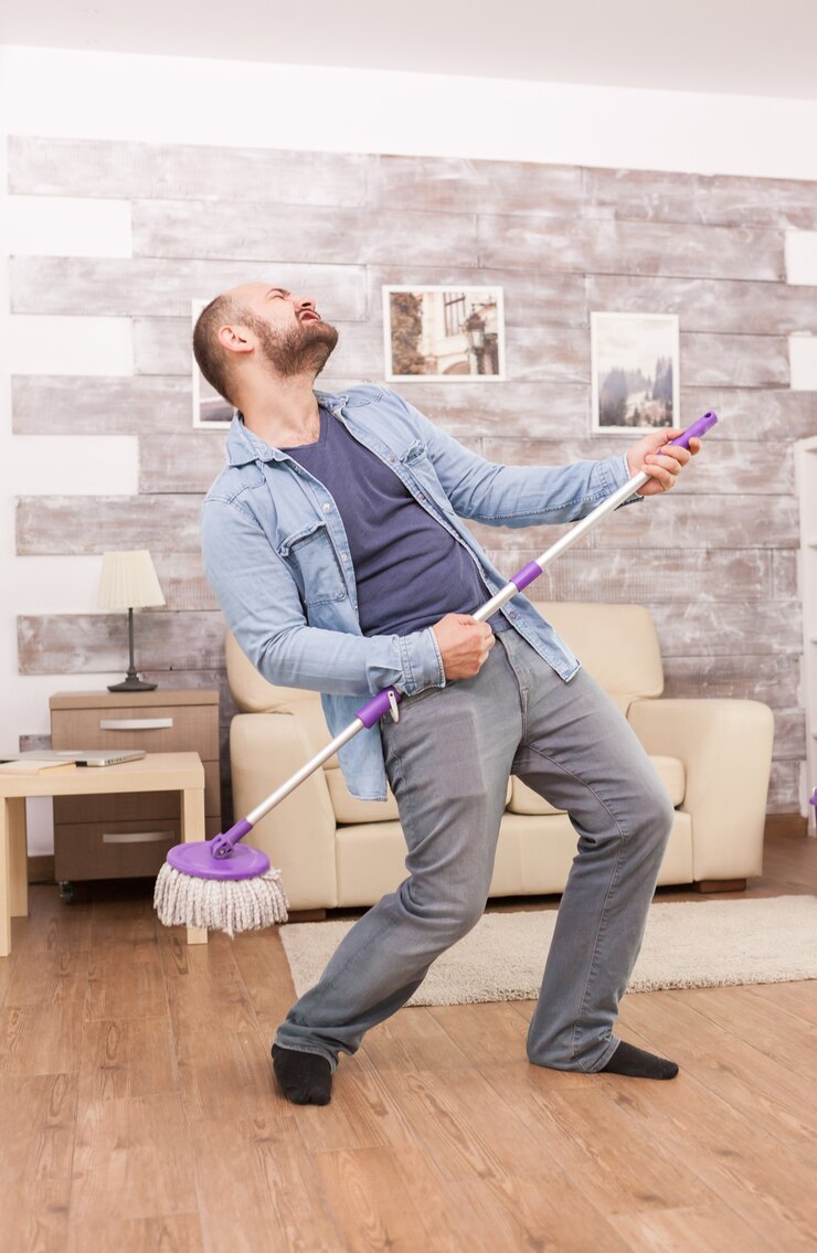 Free Photo cheerful husband dancing and cleaning the floor apartment