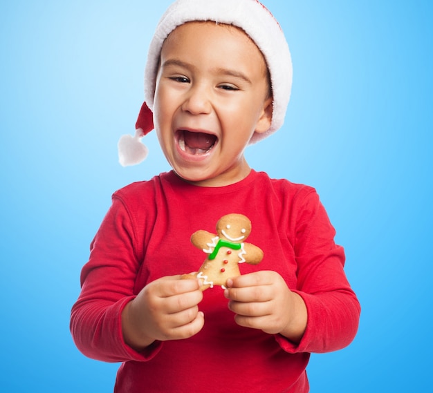 Cheerful kid holding a gingerbread